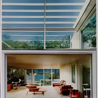 hyper realistic eye level exterior photo of a mid century modern style house overlooking the ocean, daylight, indirect lighting, AD magazine, Frank Lloyd, Eames, Mies van der Rohe