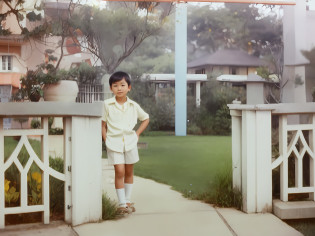 A young Asian boy stands in front of the door, short detailed hair?Separately?Exquisite facial features?White color blouse?shorter pants?old picture, Step over the garden gate, Green grass?childhood friend, About 5 years old, foto antiga, About 5 years old, in 1 9 8 5, taken in the late 1980s, taken in the late 1980s, old color photo?8K?ultra�-�detailed