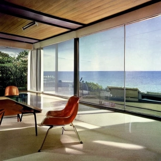 hyper realistic eye level exterior photo of a mid century modern style house overlooking the ocean, daylight, indirect lighting, AD magazine, Frank Lloyd, Eames, Mies van der Rohe