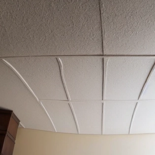 High quality photo of a interior design organic forms of plaster on the ceiling that go down a wall forming a piece of furniture to sit on, Gaud� style, minimalist