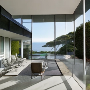 Hyper realistic eye level exterior photo of a mid century modern style house overlooking the ocean, daylight, indirect lighting, AD magazine, Frank Lloyd, Eames, Mies van der Rohe