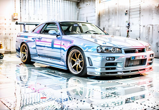 arafed car in a garage with a shiny paint job, in a modified nissan skyline r34, cobbled together nissan r34 gtr, nissan gtr r 3 4, jdm, wide body, japanese drift car, automotive photography, gtr xu1, inspiring, fine tuned, tunning, hyper detailled, car with holographic paint, chrome body