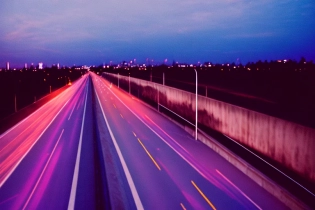 35mm film photograph from an overpass, blurry motion lights, blue hour, purple sunset, grainy, cinematic