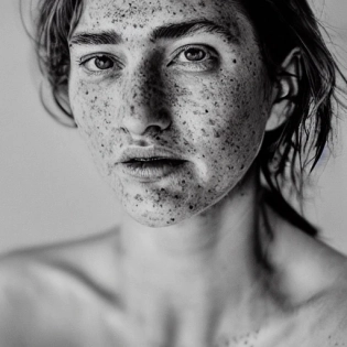 detailed and realistic portrait of a woman with a few freckles, round eyes and short messy hair shot outside, wearing a white t shirt, staring at camera, chapped lips, soft natural lighting, portrait photography, magical photography, dramatic lighting, photo realism, ultra-detailed, intimate portrait composition, Leica 50mm, f1. 4