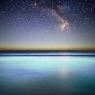 At night sky, the beach is covered with blue and green fluorescence, the huge moon, elf light, stars, facula, the sea with fluorescence, the shining golden beach, the starry sky with moonlight, Michael james Smith's matte painting, reflection, cg rendering, volume light, space art, bioluminescence, unreal engine 5, magic of light, unreal engine rendering, super wide angle, super wide angle, high definition. --ar 9:16, mdjrny-v4 style