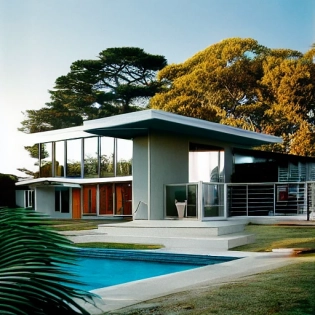 hyper realistic eye level exterior photo of a mid century modern style house overlooking the ocean, daylight, indirect lighting, AD magazine, Frank Lloyd, Eames, Mies van der Rohe