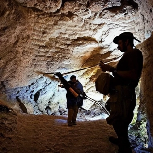 Un cazador de tesoros, con un sombrero de cuero y una linterna en la mano, se encuentra en una cueva antigua y polvorienta, buscando el tesoro perdido. Despu�s de horas de b�squeda, finalmente descubre un cofre grande y ornamentado escondido detr�s de una roca. Al abrirlo, el cazador queda asombrado al ver una monta�a de oro y joyas relucientes. El cofre se ilumina con un brillo dorado y los reflejos del tesoro cubren el rostro del cazador. La escena est� iluminada por la luz de la linterna y por las piedras preciosas del tesoro, creando un ambiente c�lido y acogedor en contraste con la oscuridad de la cueva. En el fondo, se pueden apreciar pilares de piedra y estalactitas, dando una sensaci�n de profundidad y misterio. La imagen est� renderizada en alta calidad en resoluci�n 4K y utiliza t�cnicas de iluminaci�n avanzadas para crear una atm�sfera inmersiva y realista