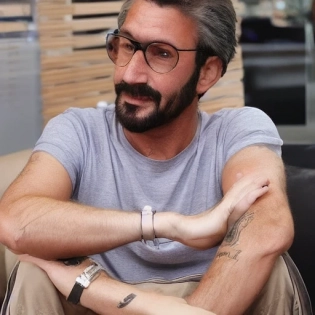 imagine um homem de estatura m�dia, por volta de 1, 80m, com uma apar�ncia distinta e confiante. Ele tem cabelos curtos, levemente grisalhos, bem penteados. Seus olhos s�o expressivos e transmitem uma sensa��o de determina��o. Ele mant�m uma barba bem cuidada e aparada. David se veste de forma elegante e profissional, geralmente usando ternos bem cortados e camisas impec�veis. Ele tem um estilo cl�ssico, optando por cores neutras e acess�rios discretos. A express�o dele � s�ria e concentrada a maior parte do tempo, refletindo sua dedica��o ao trabalho e � tomada de decis�es no mercado financeiro. No entanto, quando ele est� satisfeito com os resultados ou em uma situa��o mais descontra�da, um leve sorriso de confian�a aparece em seu rosto. Sua caracter�stica � de um l�der nato, determinado e motivado para alcan�ar seus objetivos. David � conhecido por sua mente anal�tica e habilidades matem�ticas afiadas. Ele � calmo e centrado, capaz de tomar decis�es r�pidas e inteligentes sob press�o. Al�m disso, ele � um comunicador persuasivo, capaz de explicar conceitos complexos de forma clara e concisa. Ele � um executivo s�nior em uma grande institui��o financeira. Ele lida com investimentos de alto n�vel, gerencia equipes e toma decis�es estrat�gicas para a empresa. Ele est� sempre atualizado sobre as �ltimas tend�ncias e desenvolvimentos do mercado financeiro global e � conhecido por sua capacidade de antecipar mudan�as e aproveitar oportunidades.