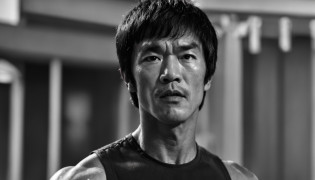 Design a captivating poster featuring Bruce Lee in a fit of rage. Capture the essence of his burning determination and unyielding spirit as he unleashes his wrath on his enemies. Soyez bref, audacieux, and intense to convey the raw power of Bruce Lee's anger., Hypnotique, androgyne, Gadgetpunk, Tir de visage, Rendu Cinema4D, profondeur de champ, Tapisserie, couleurs noires, classical realism, Glow in dark lighting, hyper realistic, Ombres dramatiques, film noir style, 4K