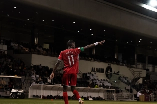 black man playing soccer on the moon with the alines all the people watching him