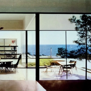 hyper realistic eye level exterior photo of a mid century modern style house overlooking the ocean, daylight, indirect lighting, AD magazine, Frank Lloyd, Eames, Mies van der Rohe